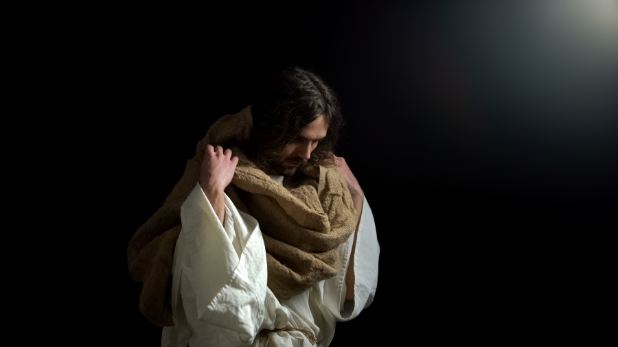 Biblical prophet with lowered head standing in darkness, spiritual confession